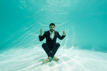 Arabian businessman meditating in swimming pool