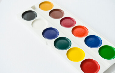 Multicolored paints on a white background. Image with selective focus