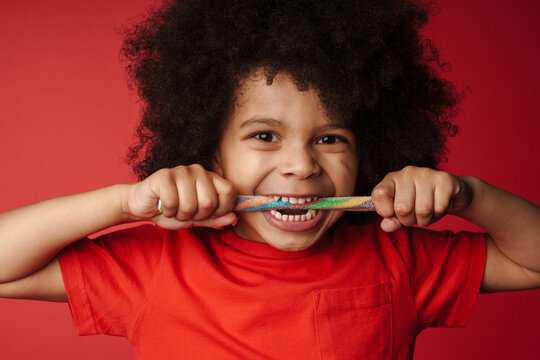 Close Up Of A Happy African Little Kid Eating Candy Cane