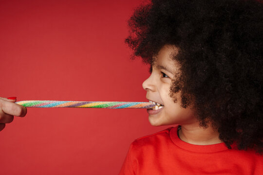 Close Up Of A Happy African Little Kid Eating Candy Cane