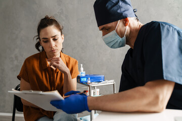 Obraz premium Woman patient and man doctor sitting in the cabinet