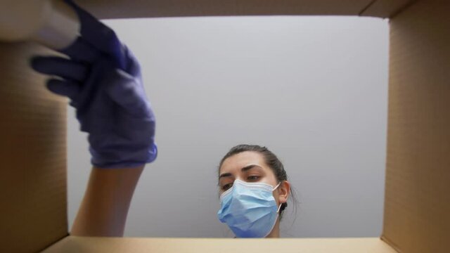 delivery, shipping and pandemic concept - woman in protective medical mask and gloves packing parcel box with beauty and dental care products
