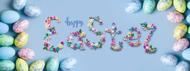 Congratulatory easter background. Easter eggs and flowers. Selective focus. Top view. Background with copy space.