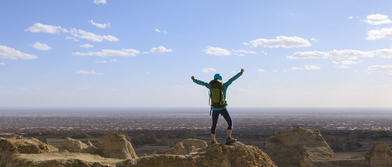 Successful female backpacker feel free on desert hill top