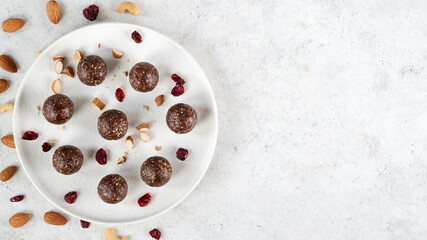 Energy balls - homemade healthy raw vegetarian dessert of nuts, dates, peanut butter, cocoa powder, coconut flakes, oats. Healthy eating. Fitness snack. Selective focus. Top view. Copy space