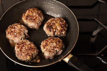 The process of cooking and roasting beef meat cutlets in a frying pan