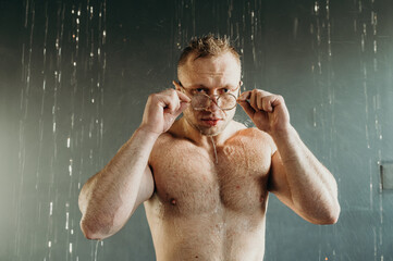 Muscular fitness shirtless man in glasses.