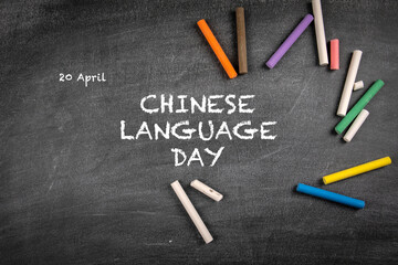 Chinese Language Day 20 April. Colored pieces of chalk on a background of a dark chalk board