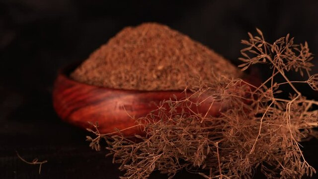 Caraway plant with carvi or cumin seeds on wooden table with black background, indian popular spice zira or jeera,