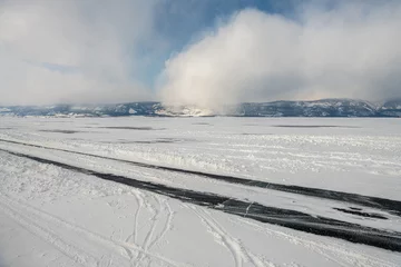 Fotobehang Icy road near Zamogoy Island in Baikal lake in winter in Irkutsk Region, Russia © evdokimari