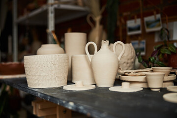 Wooden table with handmade pottery in workshop