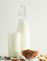 A glass with almond milk and the bowl with almonds