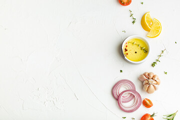 Food cooking background on white stone rustic table with fresh ingredients, vegetables, herbs, spices, olive oil from above with space for text