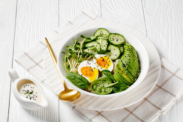 bowl with quinoa, greens, avocado and boiled egg