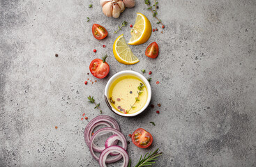 Food cooking ingredients arranged on grey stone rustic table with healthy vegetables, herbs,...