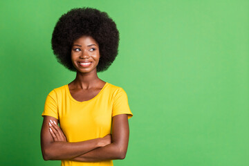 Photo of young happy smiling cheerful charming afro girl looking copyspace with crossed arms isolated on green color background