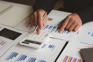 businessman working on desk office with using a calculator to calculate the numbers, finance...