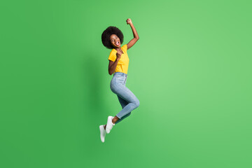 Fototapeta na wymiar Full length body size photo of jumping girl gesturing like winner happy isolated on bright green color background