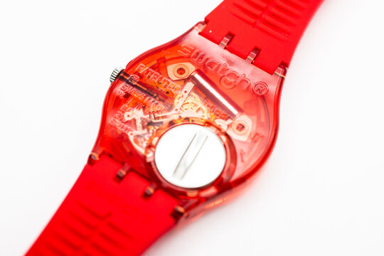 Paris, France 07.10.2020 - Swatch trendy swiss made quartz red color watch back case battery compartment. open electronic mechanism in transparent case