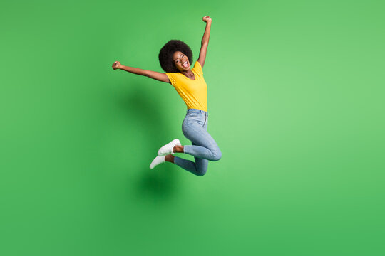 Full Size Photo Of Young Happy Crazy Smiling Positive Afro Girl Jumping In Victory Success Isolated On Green Color Background