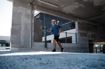 Fitness, workout, sport, lifestyle concept. Middle-aged man running in the city