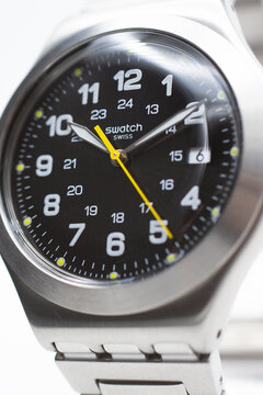 Geneve, Switzerland 07.10.2020 - Swatch logo on black wristwatch dial of swiss made mechanical watch close up. Yellow seconds arrow. Time is ticking concept. Swatch Group watch production. 10.10 PM