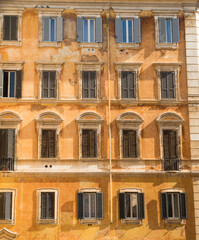 Fototapeta na wymiar Typical old roman house facade with multiple windows ornaments. 