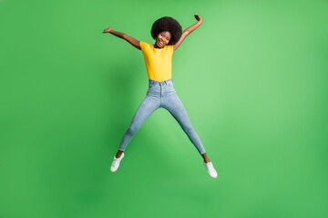 Fototapeta na wymiar Full length body size photo of jumping girl pretending star carefree laughing isolated on bright green color background