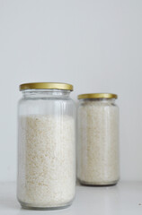 White Vietnamese Jasmine Infused rice stored in glass jar in white background.
