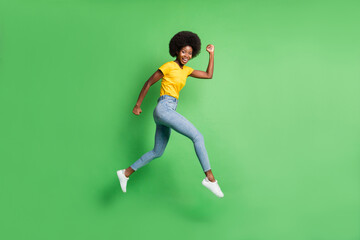 Fototapeta na wymiar Full length body size side profile photo of jumping girl running fast smiling isolated on vivid green color background