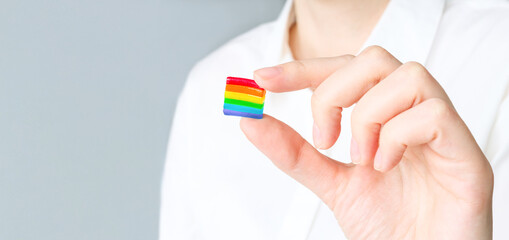 The man is holding the lgbt flag in his hands. Banner with copy space.