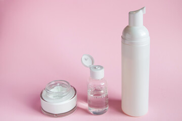 Set of cosmetics for skin care and cleansing on pink background. The concept of purity and body health. Place for text.