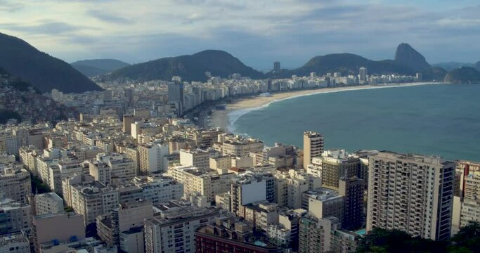 Aerial shot of tropical paradise Copacabana Beach, panning to reveal the slums of Cantagolo Hill in Rio de Janeiro.