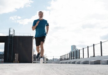 Fitness, workout, sport, lifestyle concept. Middle-aged man running in the city