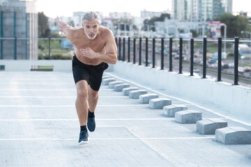 Fitness, workout, sport, lifestyle concept. Middle-aged man running in the city