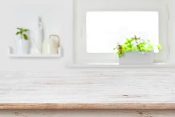 Wooden tabletop with copy space over blur kitchen window background