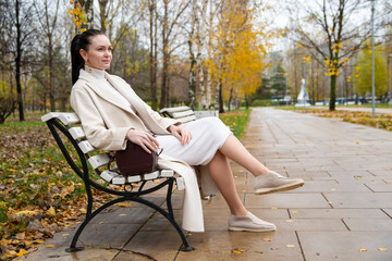 beautiful caucasian woman sitting on a bench in the park