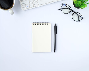 Top view above of White office desk table with keyboard, notebook, coffee cup with equipment other office supplies. Business and finance concept. Workplace, Flat lay with blank copy space.