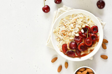 Healthy oatmeal porridge with cherry slices and nuts