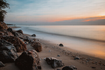 long exposure Sea rocks Magnificent sunrise view at sunrise Romantic atmosphere in peaceful morning at sea. Pink horizon with first hot sun rays.
