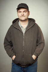 Naklejka premium Man in black hooded shirt and black hat posing as criminal