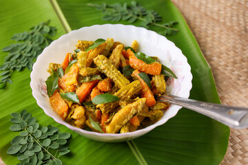 Aviyal curry for Onam Sadhya mixed vegetable curry with grated coconut side dish of rice Kerala on banana leaf background Kerala, Tamil Nadu in South India. Top view Indian veg festival food.