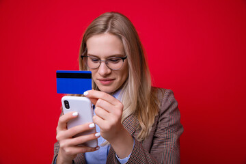 Fototapeta premium Young woman makes online purchases using a mobile phone