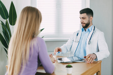 The male doctor consults the patient, shows information about his illness and talks about the medical examination.