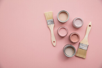 Overhead view of a DIY paint brush with pastel pink sample paint pots