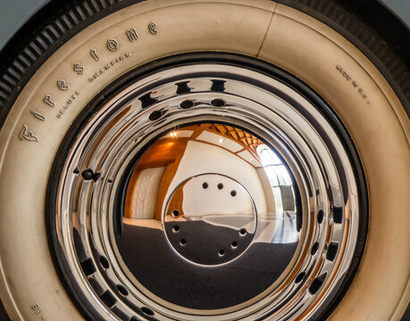 Wheel cover from a classic car with a white and black Firestone tire