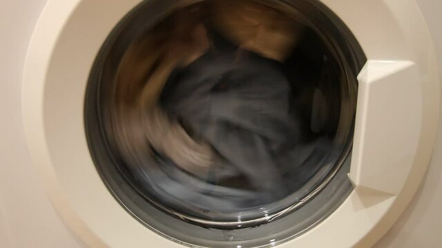 A clothing mix drying in front loaded wash machine can closeup, household washing