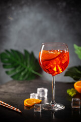 Aperol spritz cocktail in glass with fresh orange on dark background