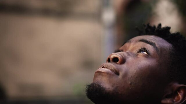 Thoughtful black man face looking at sky smiling