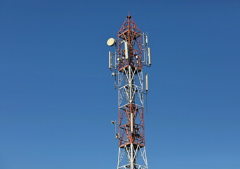 Cellular, mobile phone transmitter tower and weather station with blue sky